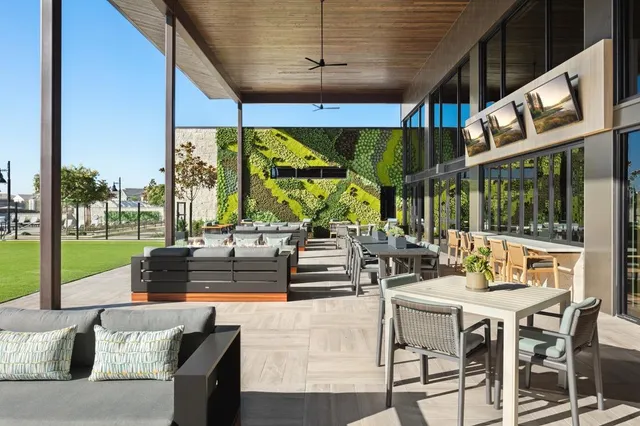 a view of a patio with a table chairs and a floor to ceiling window