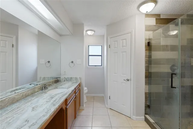 a spacious bedroom with a bed and a chandelier