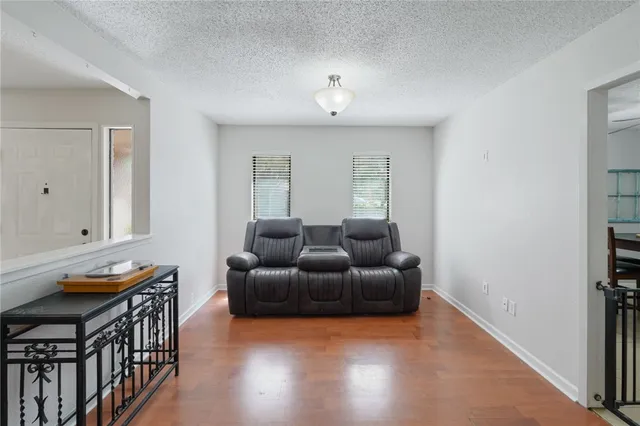 a living room with furniture a window and wooden floor