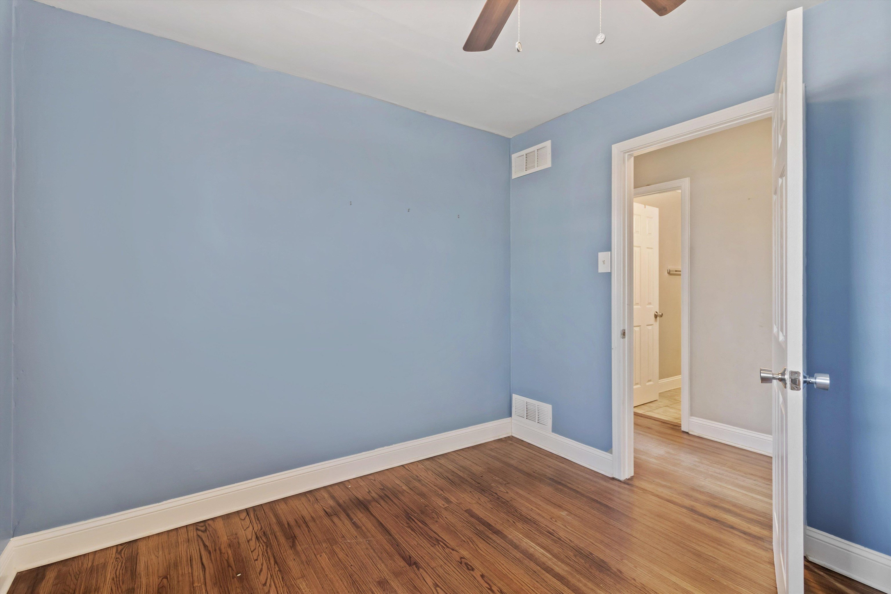 517 Malboro Road Memphis, TN 38120 - Photo 14 of 25 Empty room with a ceiling fan and wood finished floors