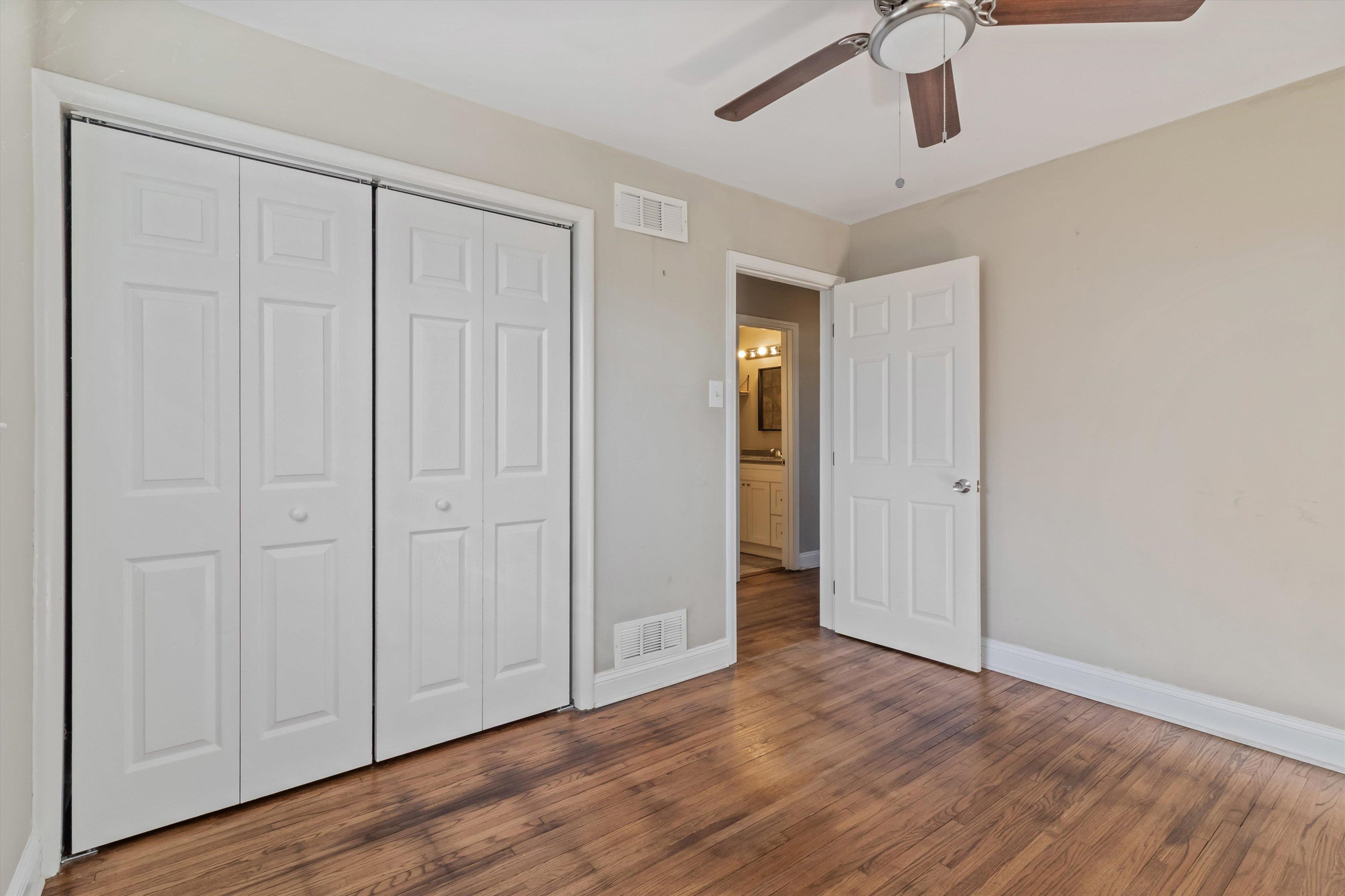 517 Malboro Road Memphis, TN 38120 - Photo 18 of 25 Unfurnished bedroom featuring a ceiling fan, dark wood finished floors, and a closet