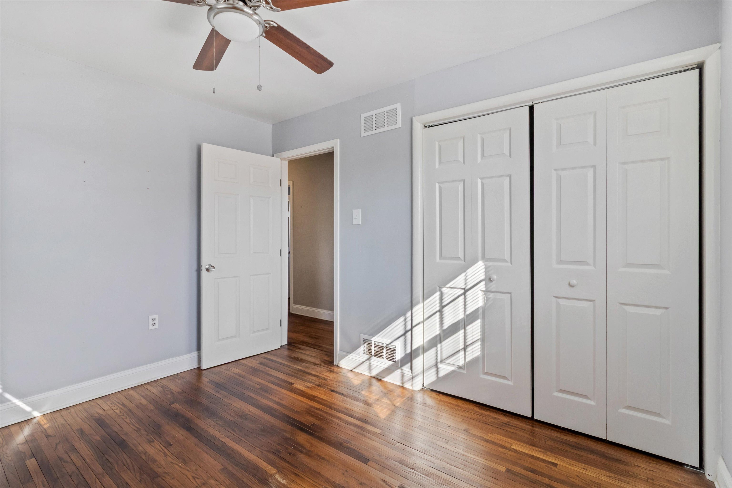 517 Malboro Road Memphis, TN 38120 - Photo 20 of 25 Unfurnished bedroom featuring a closet, dark wood-style floors, and ceiling fan