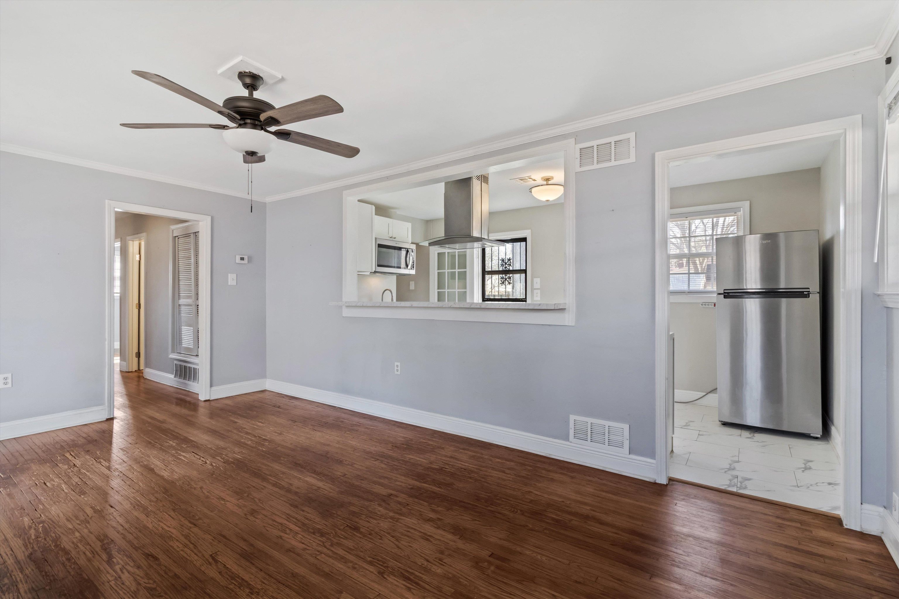 517 Malboro Road Memphis, TN 38120 - Photo 6 of 25 Unfurnished room with ornamental molding, dark wood-style floors, and ceiling fan