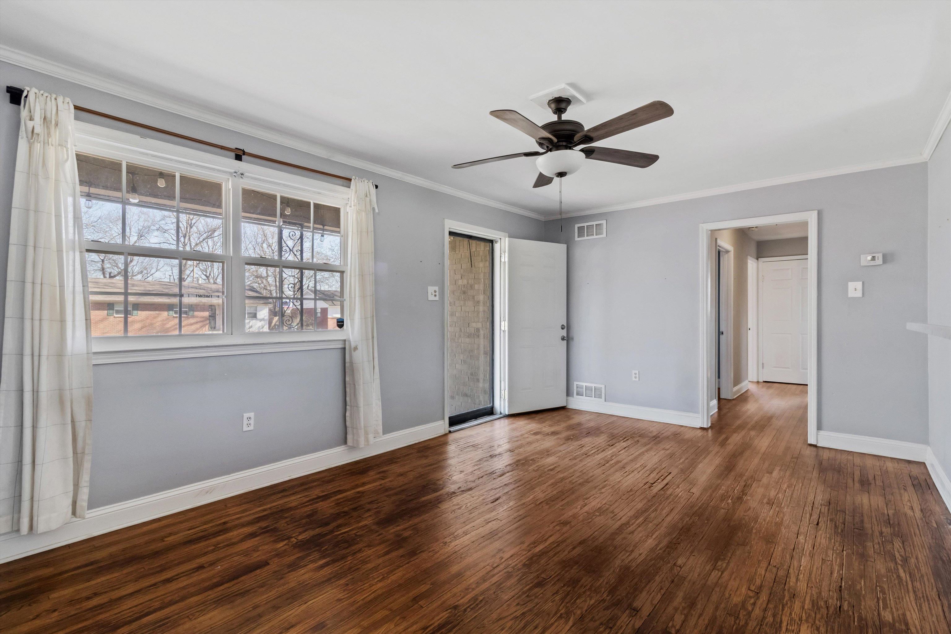 517 Malboro Road Memphis, TN 38120 - Photo 7 of 25 Unfurnished bedroom with ornamental molding, dark wood-style flooring, and a ceiling fan