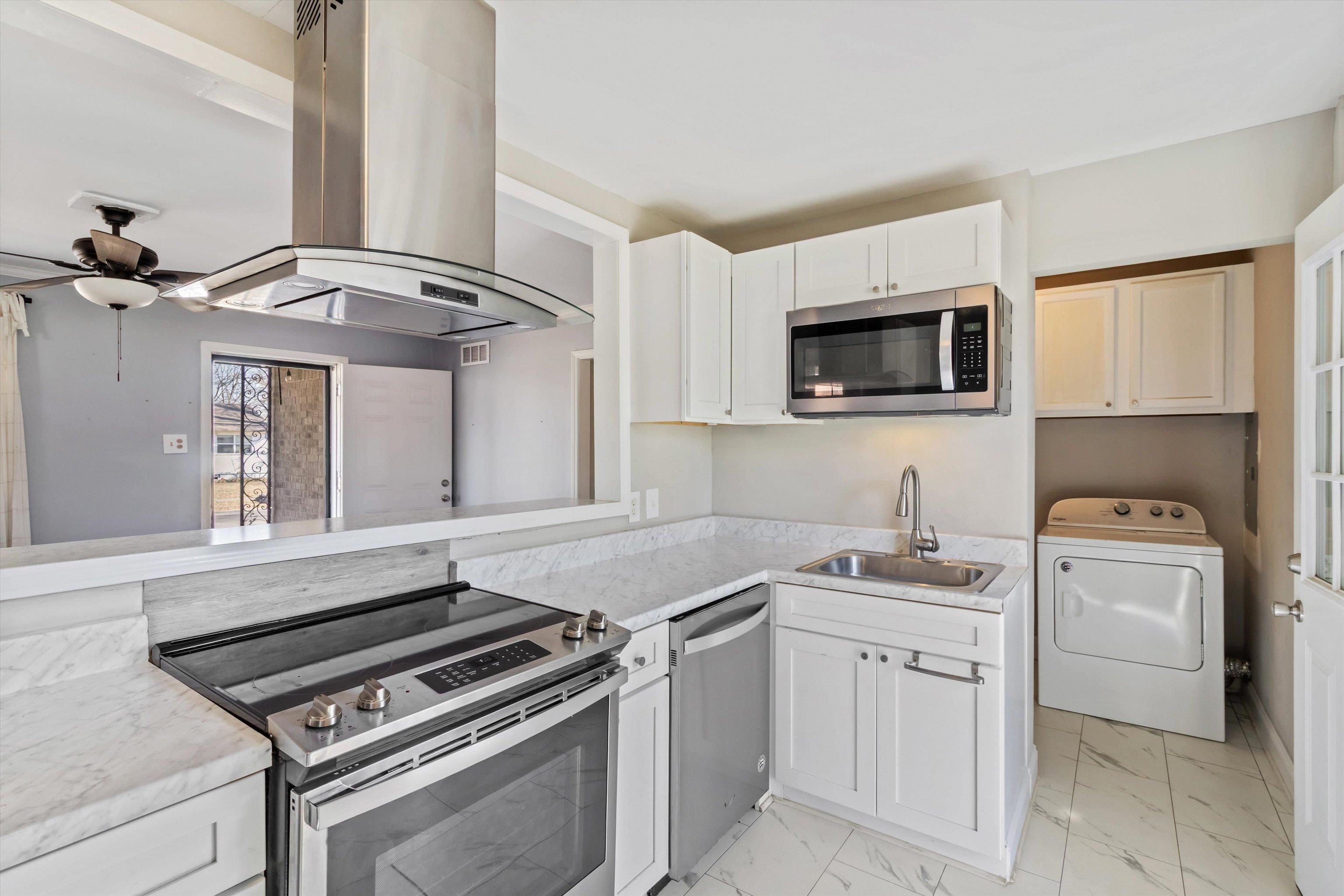 517 Malboro Road Memphis, TN 38120 - Photo 9 of 25 Kitchen featuring stainless steel appliances, washer / dryer, island range hood, and light countertops