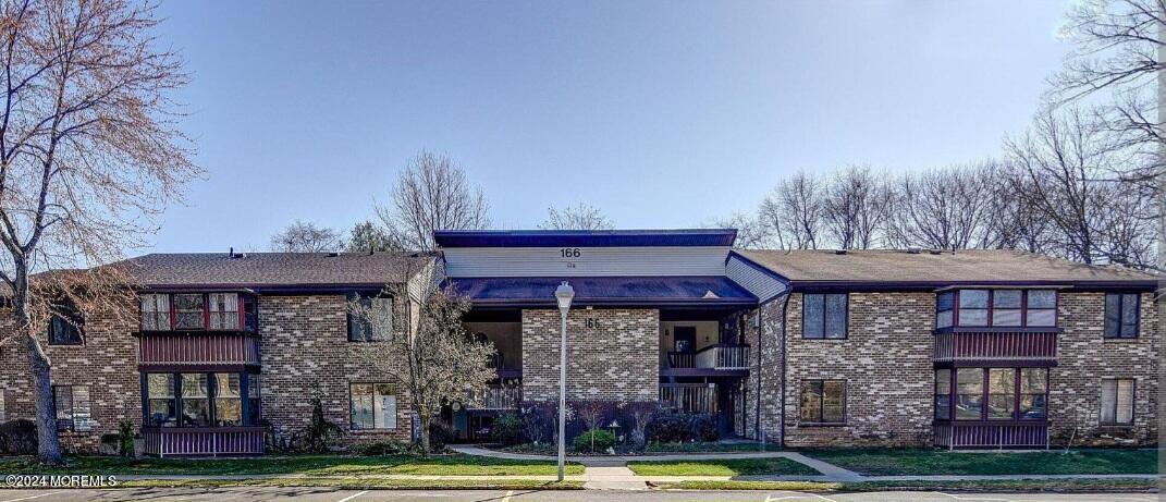 165 Cross Slope Court, Unit J Manalapan, NJ 07726 - Photo 1 of 15 a front view of a building with a swimming pool