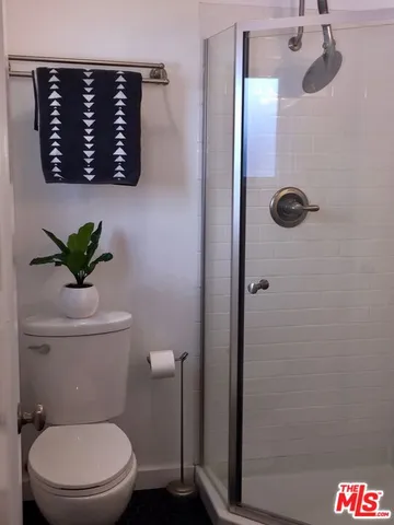 a white toilet sitting next to a shower