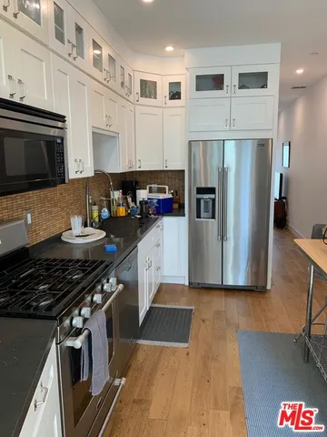 a kitchen with stainless steel appliances kitchen island granite countertop a stove and a refrigerator