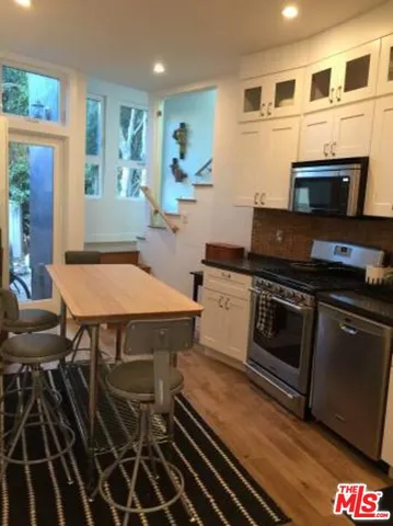 a kitchen with a stove and white cabinets