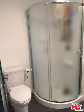 a white toilet sitting next to a shower
