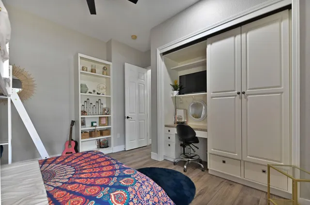 a view of a livingroom with workspace and a ceiling fan