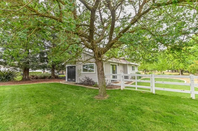 an aerial view of residential houses with outdoor space and trees