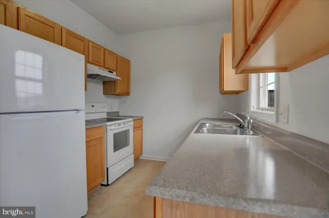 a kitchen with stainless steel appliances granite countertop a sink a stove and a refrigerator