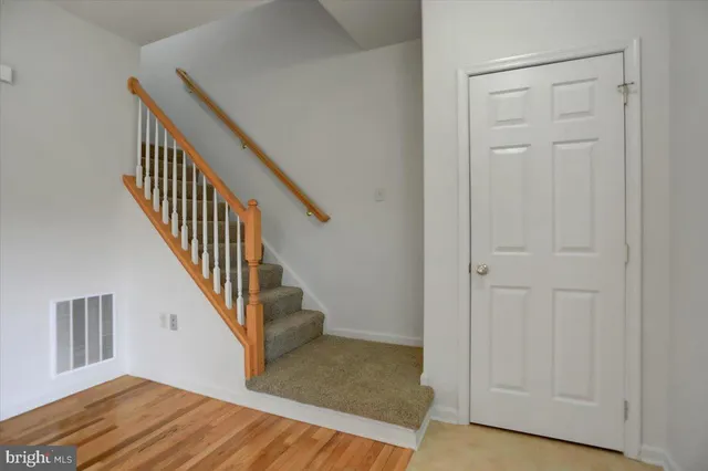 a view of a hallway with wooden floor and entryway