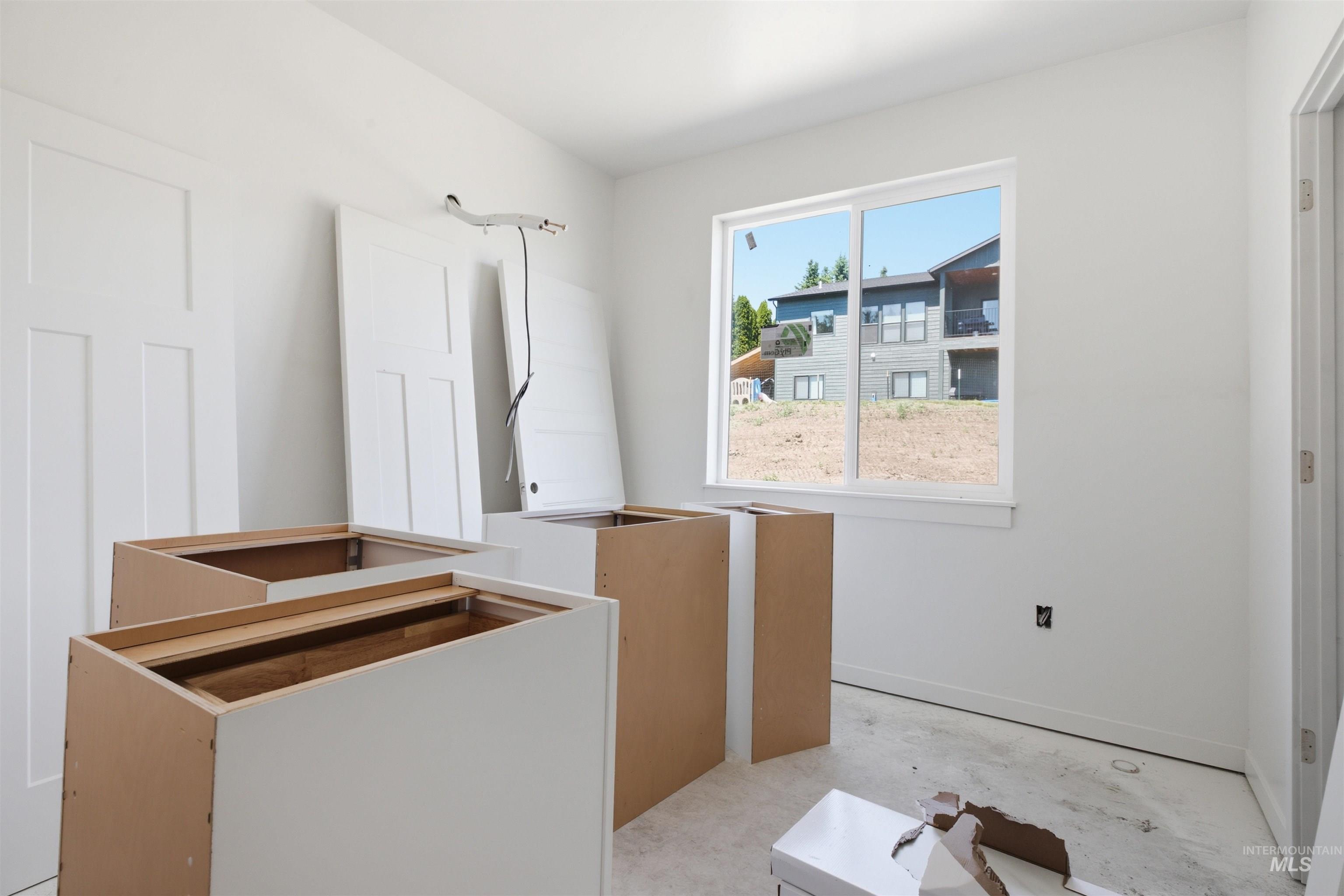 2812 Cyprus Court Moscow, ID 83843 - Photo 5 of 22 White cabinetry in a modern bathroom setting featuring a built-in bathtub with white tile surround and marble-look flooring