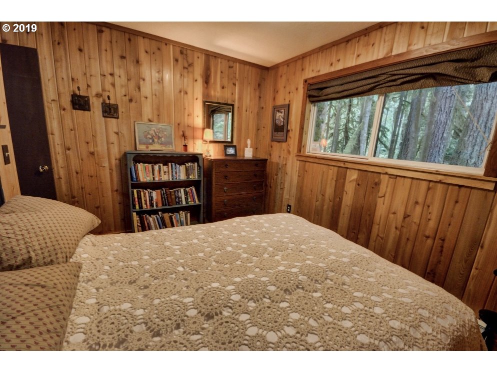 75191 East E Road Rhododendron, OR 97049 - Photo 19 of 32 a bedroom with a bed closet and a large window