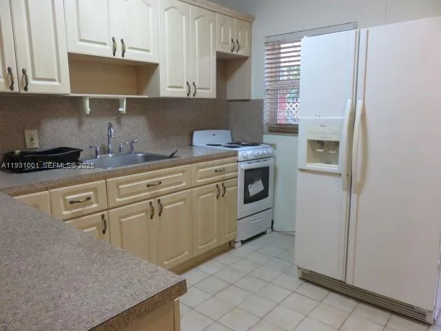 a kitchen with white cabinets and white appliances