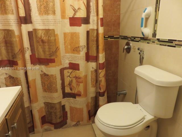 2820 Southwest 16th Terrace, Unit EFF Miami, FL 33145 - Photo 3 of 8 a white toilet sitting next to a bathroom sink and a shower