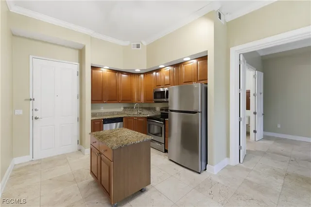 a kitchen with kitchen island granite countertop stainless steel appliances and wooden cabinets