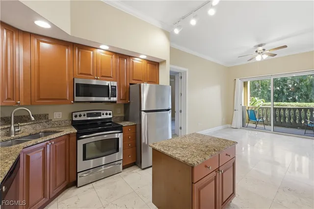 a kitchen with stainless steel appliances granite countertop a refrigerator and a stove top oven
