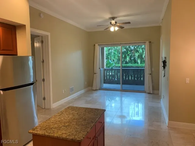 a view of a kitchen with a refrigerator and wooden floor