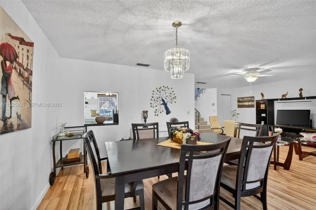 a view of a dining room with furniture a chandelier and wooden floor