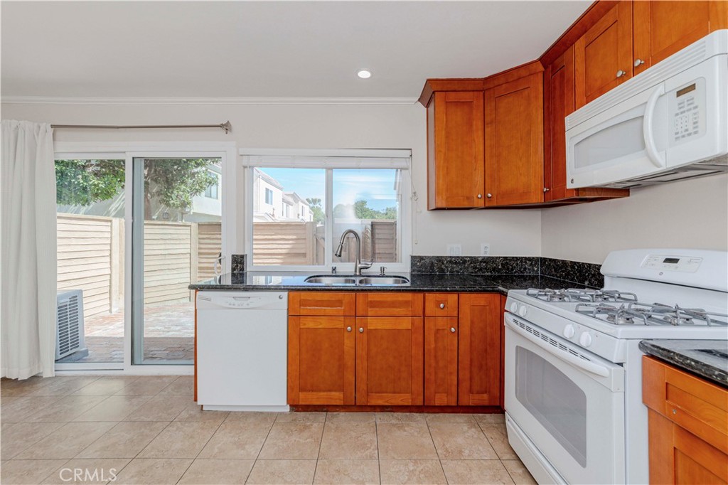 49 Meadowgrass Irvine, CA 92604 - Photo 6 of 25 a kitchen with stainless steel appliances granite countertop a stove a sink and a microwave