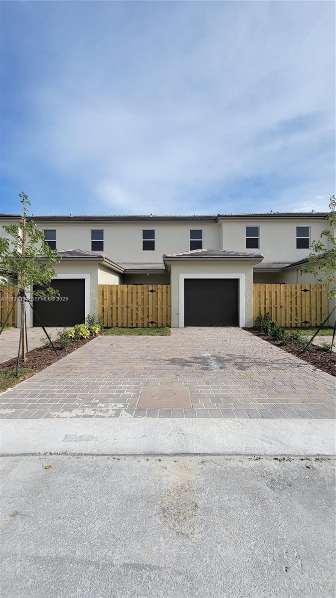 26430 Southwest 148th Court, Unit 26430 Homestead, FL 33032 - Photo 20 of 21 a front view of a building with a yard and garage