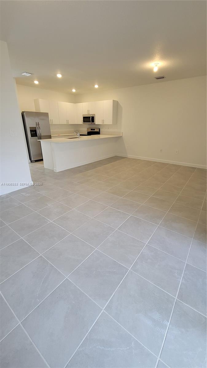 26430 Southwest 148th Court, Unit 26430 Homestead, FL 33032 - Photo 5 of 21 a view of a kitchen with a sink and a stove top oven