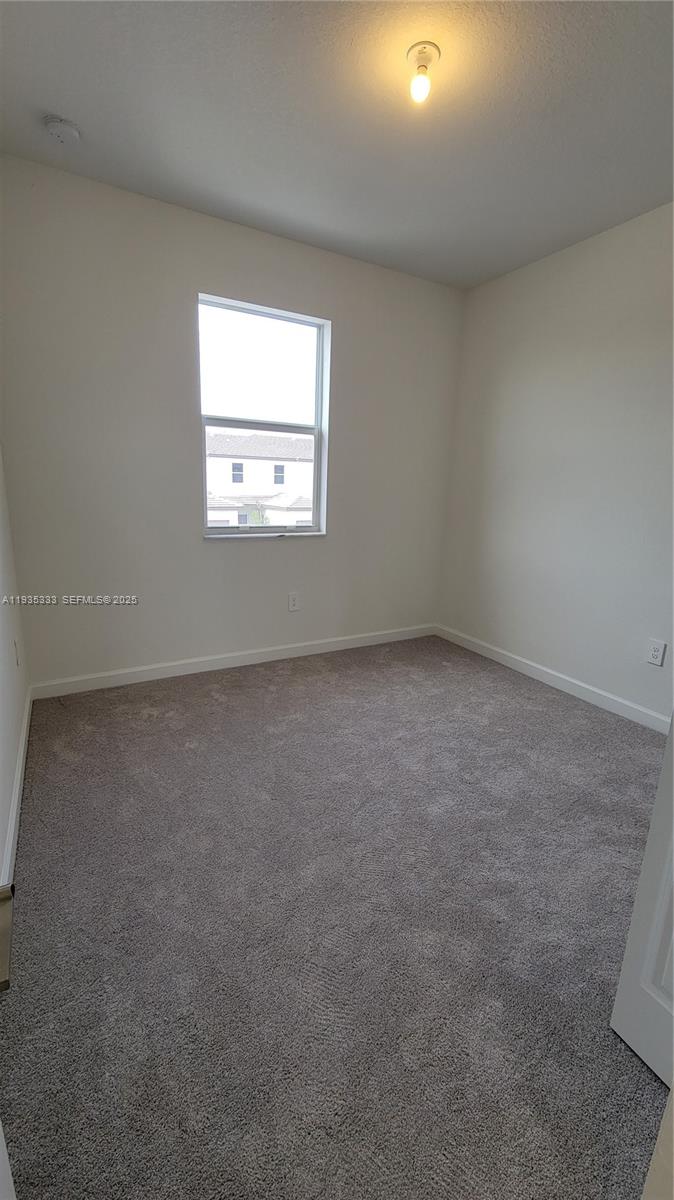 26430 Southwest 148th Court, Unit 26430 Homestead, FL 33032 - Photo 9 of 21 an empty room with a window