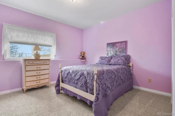 a spacious bedroom with a bed and a dresser