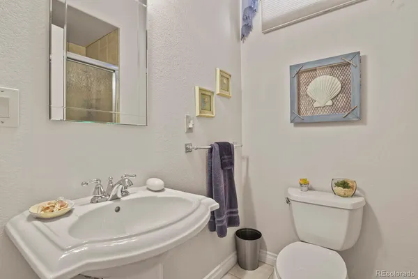 a bathroom with a toilet a sink and mirror