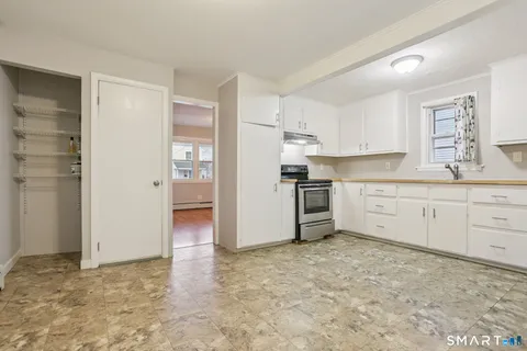 a kitchen with white cabinets and white appliances