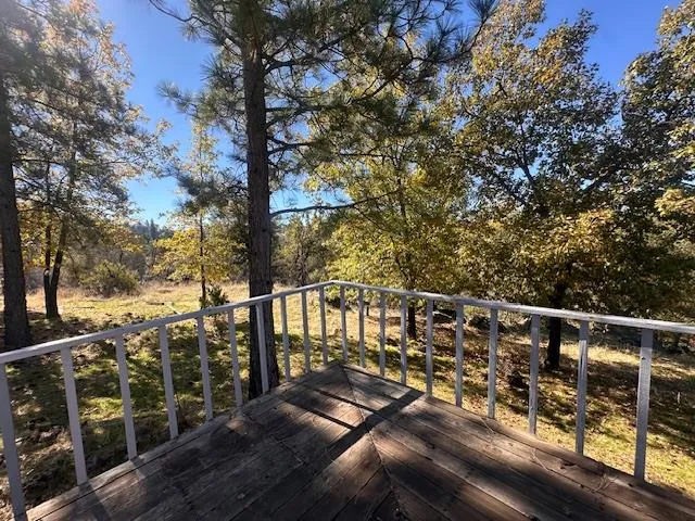 a view of a balcony with wooden floor and fence