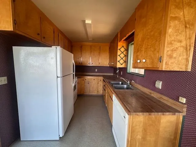 a kitchen with stainless steel appliances granite countertop a refrigerator a sink and a stove