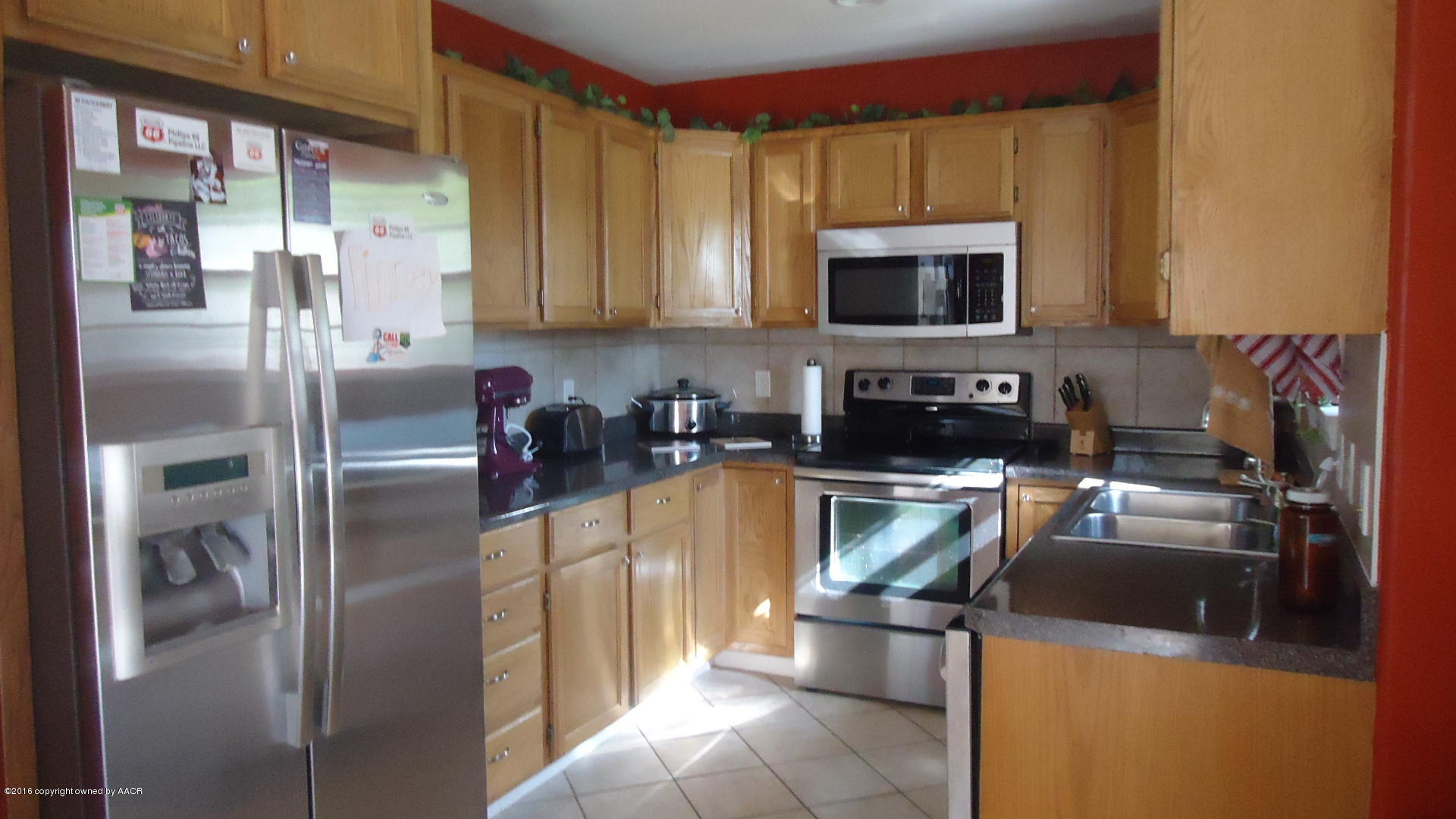 4412 South Austin Street Amarillo, TX 79110 - Photo 3 of 10 a kitchen with a refrigerator and a stove top oven