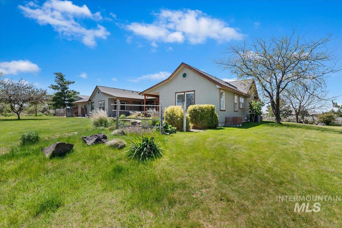 147 East Indian Crk Road Boise, ID 83716 - Photo 34 of 43 Expansive green lawn surrounding a single-story residence with a covered patio and established trees