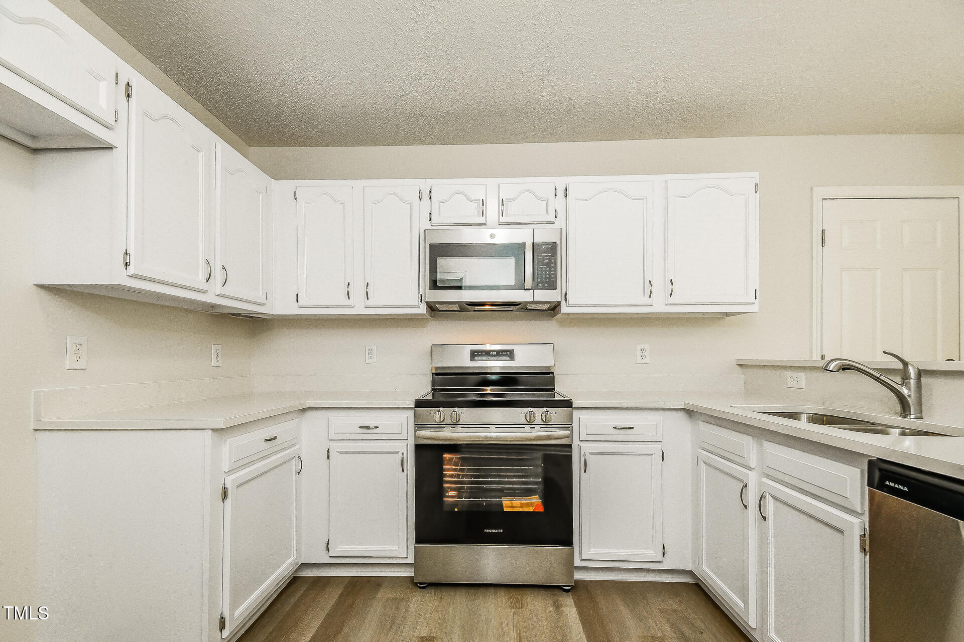 1003 Walnut Drive Erwin, NC 28339 - Photo 5 of 16 a kitchen with white cabinets and stainless steel appliances