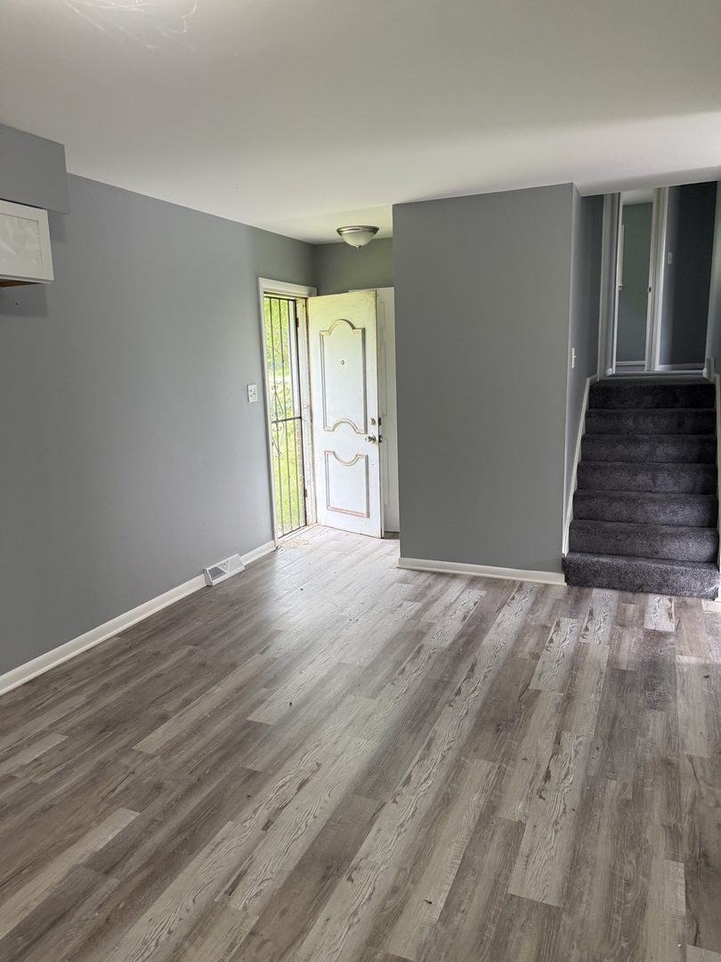 2352 West 157th Place Markham, IL 60426 - Photo 13 of 28 a view of an empty room with wooden floor and a window