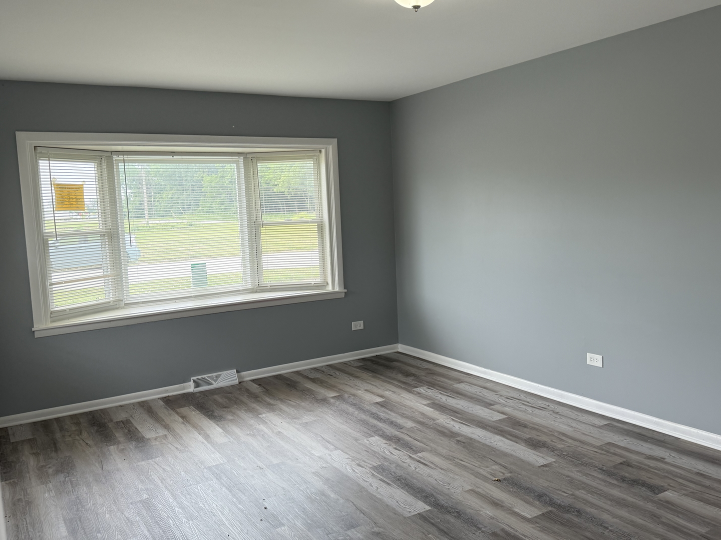 2352 West 157th Place Markham, IL 60426 - Photo 6 of 28 a view of an empty room with wooden floor and a window