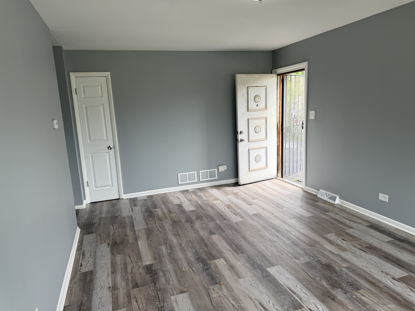 2352 West 157th Place Markham, IL 60426 - Photo 8 of 28 a view of an empty room with window and wooden floor