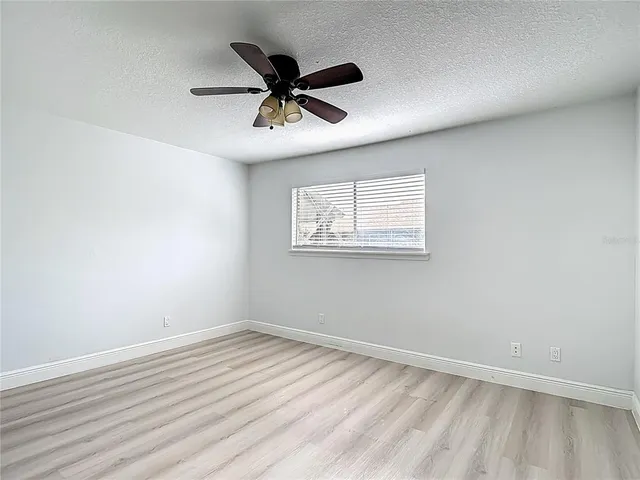 a view of a big room with wooden floor and windows