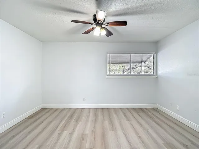 a view of a room with wooden floor and a ceiling fan