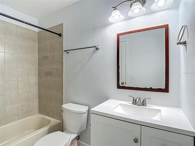 a bathroom with a sink vanity mirror and toilet
