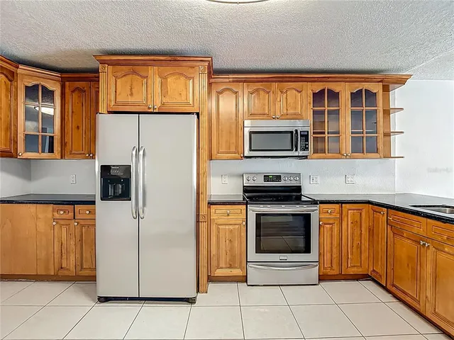 a kitchen with stainless steel appliances granite countertop a refrigerator and a stove top oven