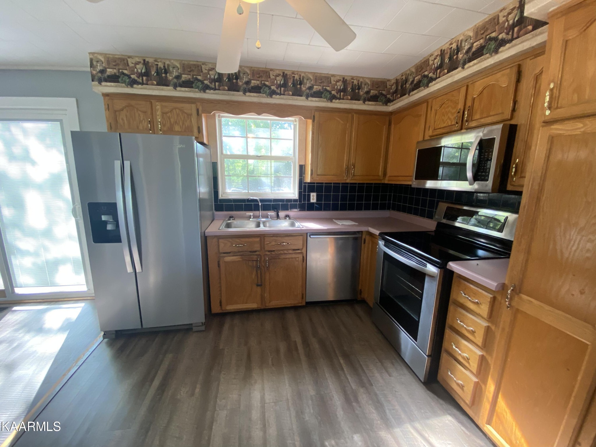 132 Dustin Lane Oneida, TN 37841 - Photo 14 of 27 a kitchen with stainless steel appliances a refrigerator a sink a stove a microwave and wooden floors