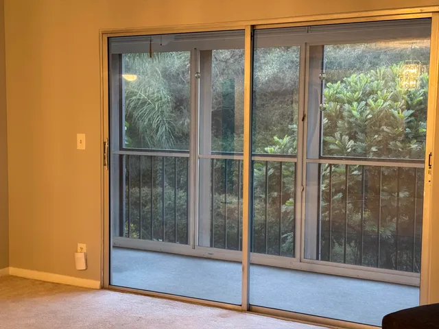 a view of a small space with wooden floor and a window