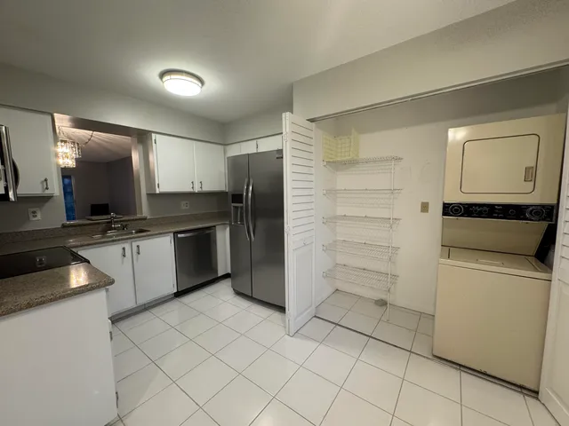 a view of a yard with plants and a bench