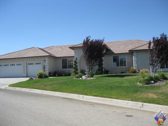 a view of a house with a big yard plants and large trees