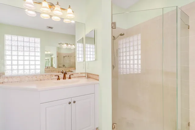 a bathroom with a sink a mirror and a shower